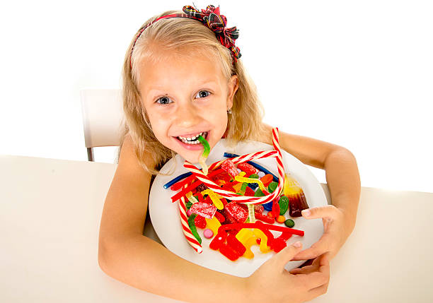 pretty-happy-child-eating-candy-sweet-sugar-abuse-dangerous-diet